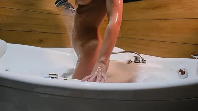 Beautiful blonde seductively teases her tits in a bubble bath